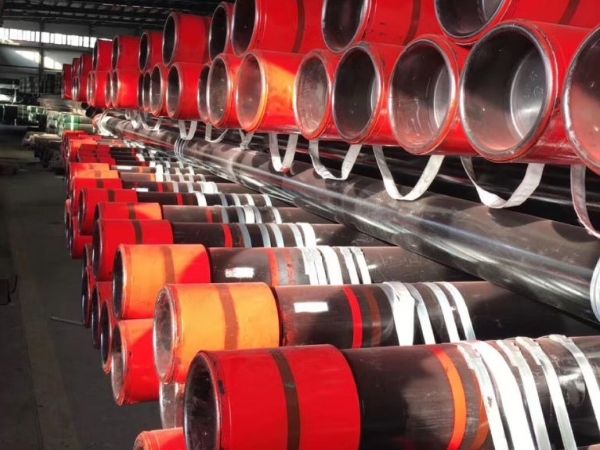 2 layers of pipes on the shelf are covered with oilfield thread protectors