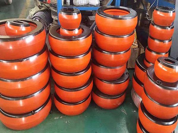 Front view of several piles of orange integral inflatable thread protectors in factory