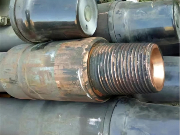A drill pipe with rusty threads without thread protector on top of several pipes