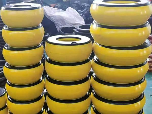 Front view of several piles of yellow integral inflatable thread protectors in factory